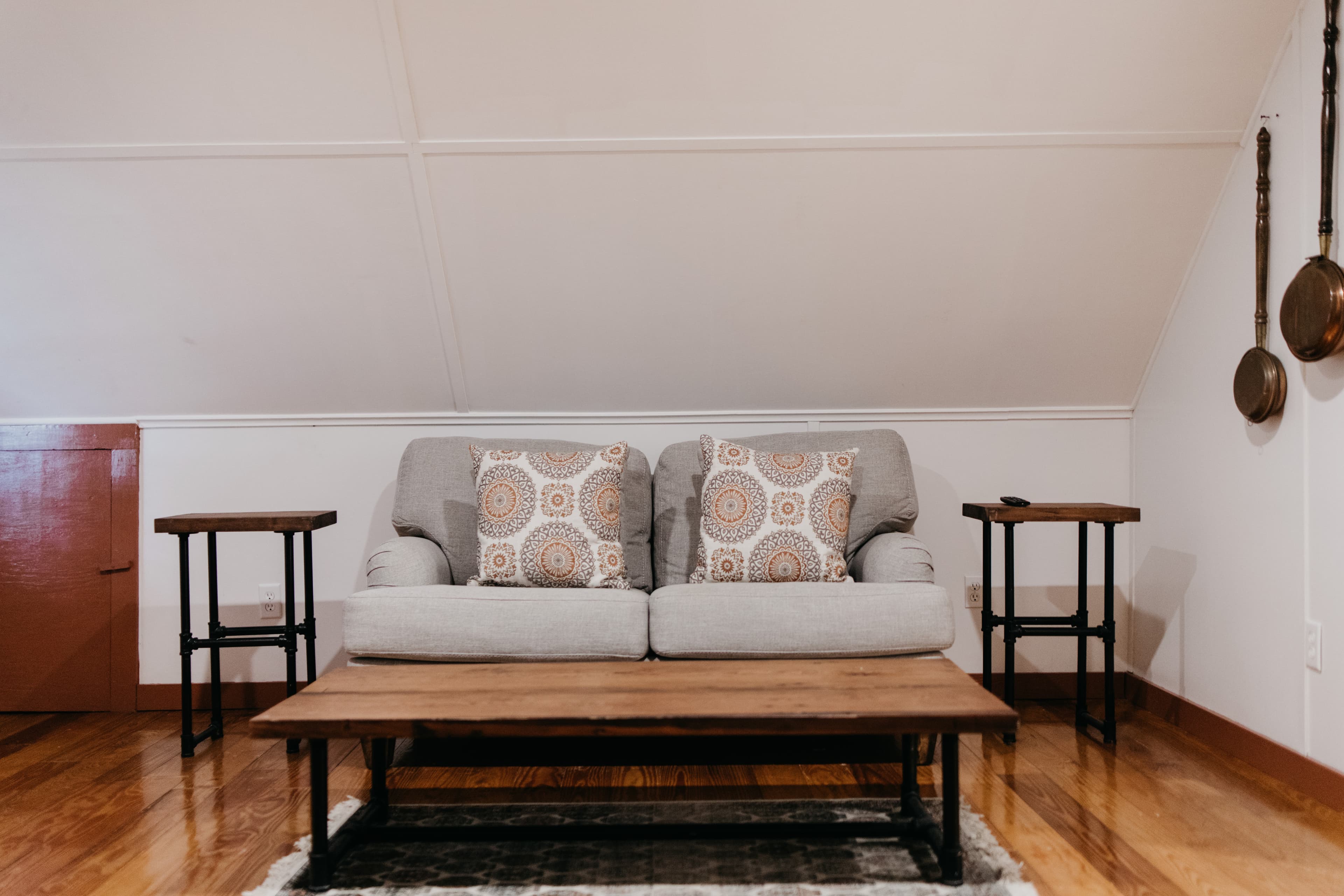 Cozy living room with a gray sofa, patterned pillows, and wooden tables.