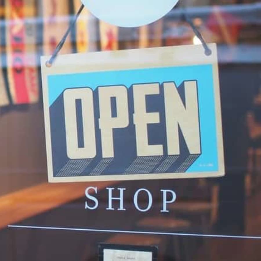 A colorful "OPEN" sign hanging in a shop window.