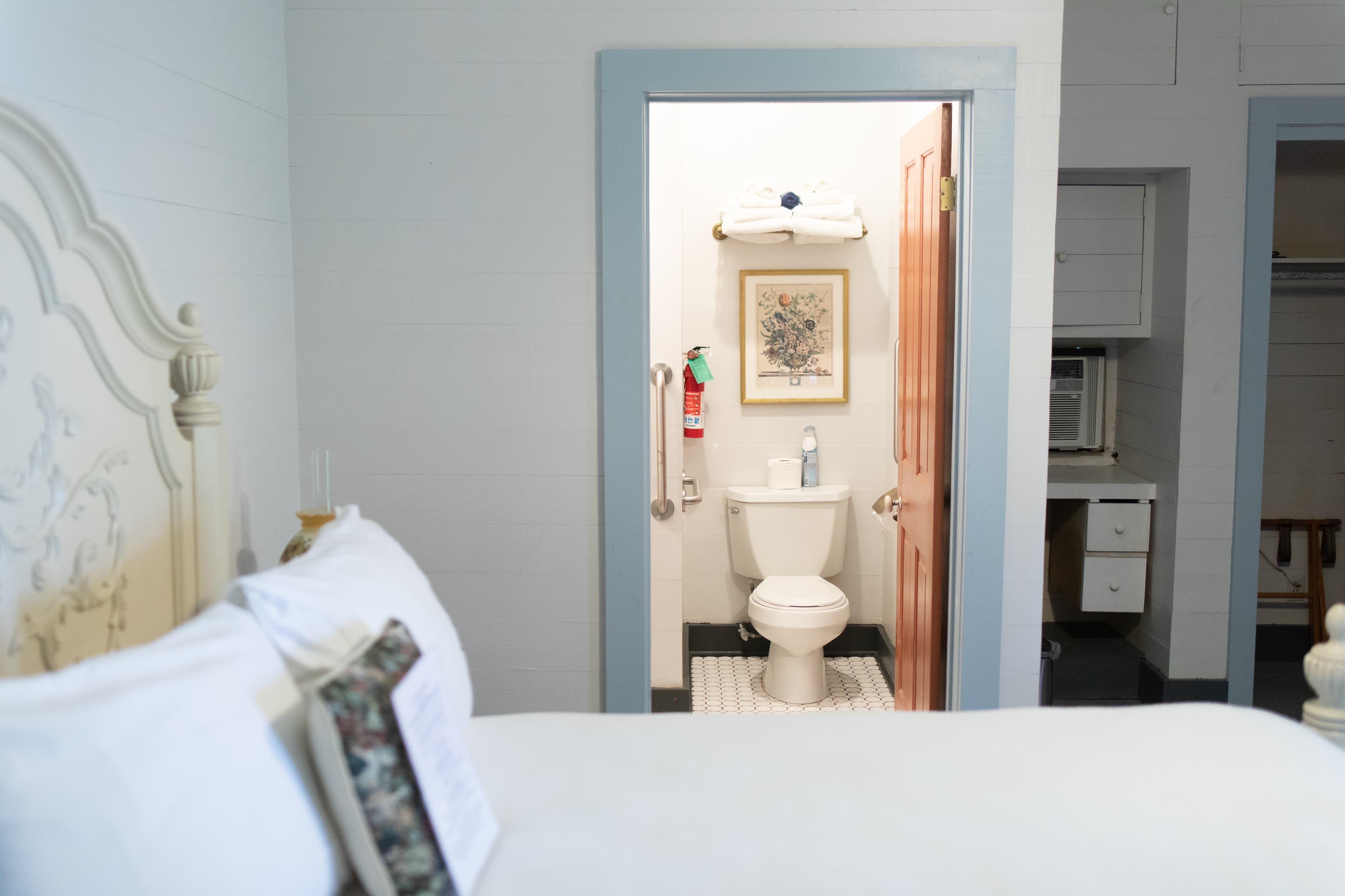 A cozy bedroom with a view of the adjoining bathroom.