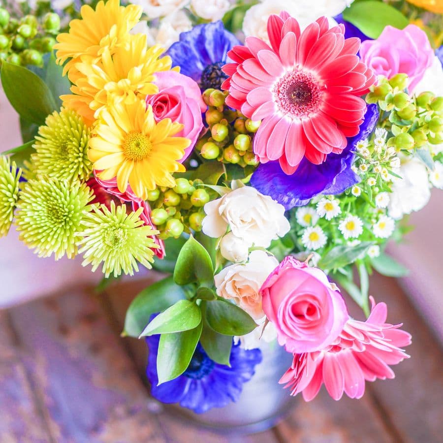 A vibrant floral arrangement featuring a variety of colorful flowers in a vase.